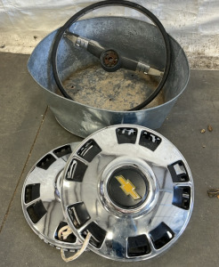CHEVY METAL HUB CAPS, OLD STEERING WHEEL, AND METAL CONTAINER; PLEASE INSPECT