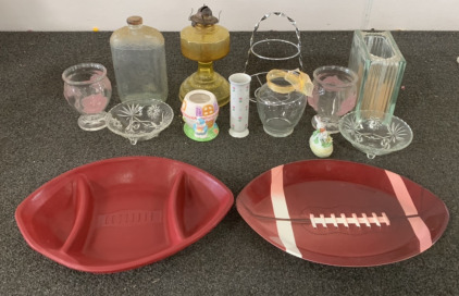 (1) GLASS OIL LAMP (3) GLASS VASES, (1) CERAMIC EASTER JAR, (1) CUTTING BOARD, (2) PLASTIC FOOTBALL PLATTERS AND MORE