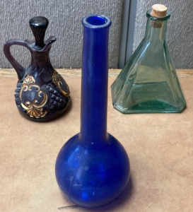 (1) ROYAL BLUE GLASS VASE, (1) GREEN CORKED GLASS, (1) PURPLE AND GOLD BATH OILS BOTTLE