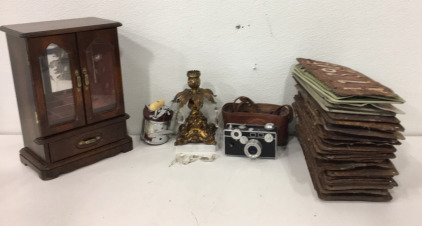 (1) Jewlery Box (1) Penn Jig Master Fishing Reel<br/>(1) Decorative Candel Holder<br/>(1) Argus Coated Cintar Camera<br/>(46) Vintage Idaho Liscense Plates