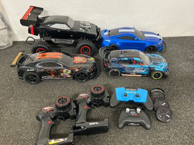 4 UNUSED R/C CARS WJTH CONTROLLERS