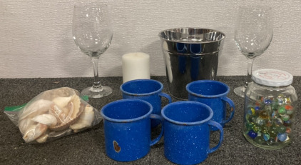 (2) WINE GLASSES, METAL BUCKET, WHITE CANDLE, BAG OF SEASHELLS, (4) BLUE AND WHITE SPECKLE CAMPING MUGS, JAR OF MARBLES