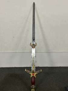 2-HANDED CRUSADE SWORD WITH LION HEADS WITH FAUX JEWELS ON THE HANDLE AND HILT-BLADE IS 41” LONG FROM HILT