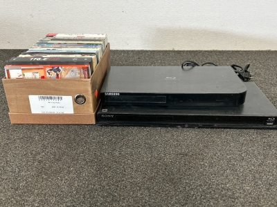 SONY BLU-RAY PLAYER, SAMSUNG BLU-RAY PLAYER (BOTH POWER ON, TRAYS OPEN) AND SHOEBOX WITH TV SERIES DVD&rsquo;S: NIP TUCK, DEXTER, HOW I MET YOUR MOTHER, TRUE BLOOD AND MODERN FAMILY