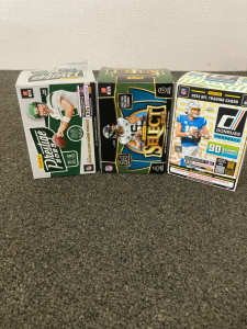 Football Cards (3) Boxes, Including Aaron Rodgers Eite, Travis Kelcy Prestige, Lamar Jackson Pink Prizm