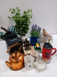 (1) Ceramica Heater (Powers on) (4) Assorted Mugs (1) Wood Cutting Board (3) Artificial Plants & More!