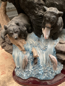 Wooden sculpture of bear with her cubs, catching fish