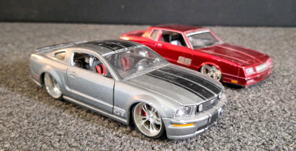 (1) MAISTO 2006 FORD MUSTANG GT 1/24 DIECAST MODEL CAR, SILVER & (1) JADA 1986 CHEVY MONTE CARLO SS, RED