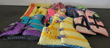 Various size life jackets and paddle oar