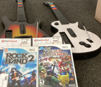 TWO GAME GUITARS FOR THE NINTENDO WII, 4 NINTENDO WII GAMES ( GUITAR HERO AEROSMITH, ROCK BAND 2, ROCK BAND 3, SUPER SMASHBROS BRAWL) PLEASE INSPECT.