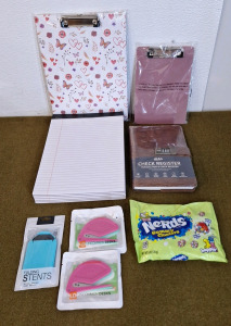 (2) Clipboards, 1-Big, 1-Small, (6) Pads Of White College Ruled Paper, (1) Check Register, (1) Pocket, Cell Phone Stand, (2) 3-Packs Of Letter Openers & (1) 6-Oz Bag Of Nerds Gummy Clusters