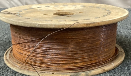 SPOOL OF THIN COPPER WIRE.
