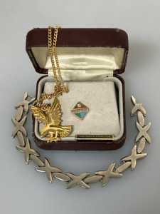 Silver Toned Bracelet, Gold Toned Eagle Necklace, and US West Pin