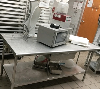 (1) Commercial Kitchen Lot w/ (1) Amana Microwave (1) Robot Coupe Food Processor & Assorted Supplies (1) Prep Table - 72"×36"