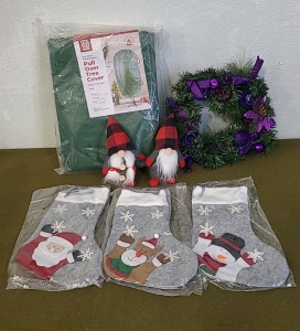 (1) Pull Over Christmas Tree Cover, (1) Advent Wreath/ Candle Holder, (1) Pair Of Christmas Gnomes, (1) 3-Piece Christmas Stocking Set, & (1) Box Of Assorted Christmas Decor