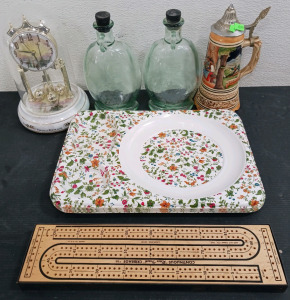 (11) Home Decor & Tabletop Items - (1) Thomas Kinkade Clock (2) Decorative Bottles (1) German Stein (6) Floral Trays (1) Cribbage Board