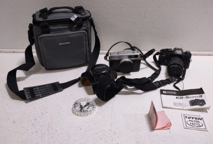 A Minolta Hi-Matic Film Camera, likely a Model from the 1960s or 70s, a Ricoh KR-5 Super II 35mm Film Camera w/ a Tiffen Lens Filter, & a Dark Gray Camera Bag