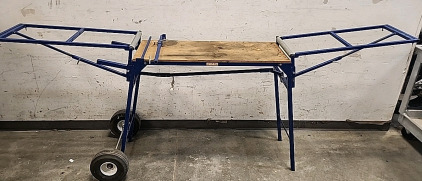 Trojan MS-2000 heavy-duty miter saw stand. It is designed for mobility and easy setup, particularly useful for moving between rooms during tasks like molding installation. Key features include: <br/>A plywood tabletop, likely around 24x40 inches, suitable