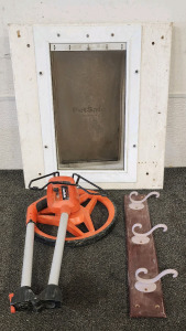 Lufkin Professional Measuring Wheel, Dog Door, And A Hangable Coat Rack.