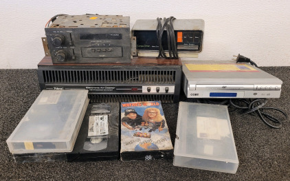 Pollenex Electric Air Cleaner, Compu Chron Alarm Clock, Delco FM Stereo, Coby DVD Player, And VHS Tapes