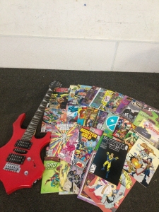 Electric Guitar and A Wide Selection of Comic books Including Super Girl,Booster Gold, who's who, and Elf Quest