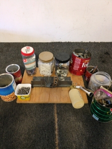 Assorted nails and screws with tie downs and a sprayer of sorts