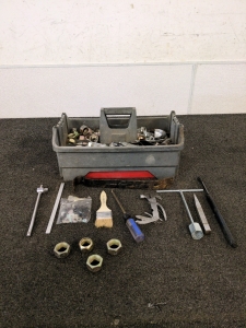 A tool box full of Semi truck lug nuts and bolts and various tools