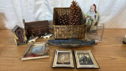 Assorted Items (2) Super sized Pine Cones (2) Woven Basket (2) Vintage Decorative Wall Art Plates (1) Fishing Picture And Frame (1) Small Log Cabin (1) Small Out House & More
