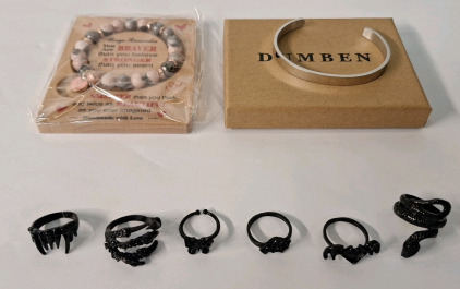 (8) Pieces Of Cosmetic Jewelry, (1) Rhodonite Bead Bracelet, (1) Stainless Steel Bracelet & (6) Black Finished, Fantasy Style Rings
