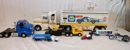 The Image Shows a Collection of Die-Cast Toy Vehicles. The Tost Prominent Item is a Nylint NAPA Tractor-Trailer Truck, Which is a Promotional Item for NASCAR Driver Ron Hornaday Jr. from 1996.