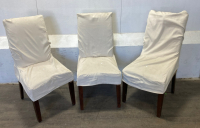 (3) Brown Dinner Chairs w/ White Covers