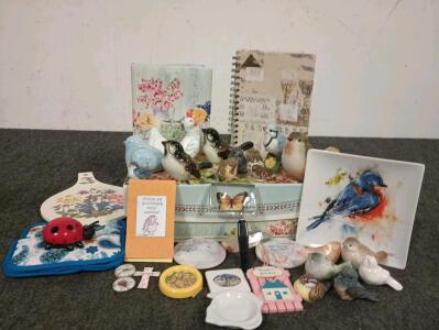 Collection of bird figurines. Decorative storage box and notebooks.