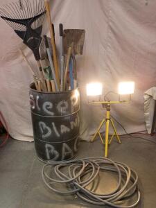 Dual-Head Halogen Work Light With a Tripod Stand. Black Barrel Full Of Various Hand Tools, 50ft Garden Hose