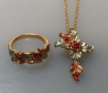 Gold-Toned Cross Necklace Featuring Detailed Floral/Leaf Design With Green/Orange Enamel Accents