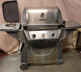 Gas Barbecue Grill, By BBQ Grillware. It Features a Main Grilling Area Under a Stainless Steel Hood and a Side Burner With its Own Cover.