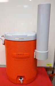 Orange Rubbermaid 5-Gallon Water Cooler With an Attachable Cup Dispenser.
