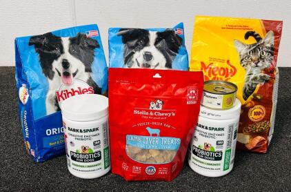 (2) Bags Of Kibbles 'n Bits, (1) Bag Of Meow Mix, (2) Bottles Of Probiotics For Dogs, (1) Small Can Of Cat Wet Food, And Lamb Liver Treats
