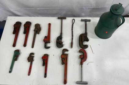 collection of pipe wrenches and one pipe cutter