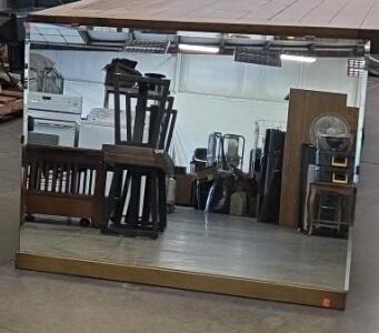 A Large Mirror Reflecting A Wooden Armoire