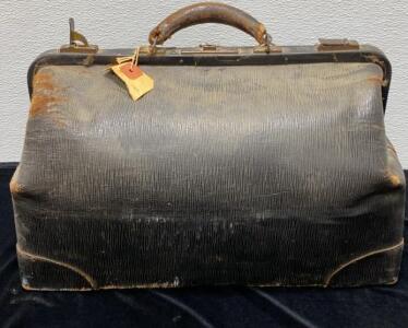 Vintage Leather Doctor&rsquo;s Gladstone Bag, Black, estimated 18"x9"x11", classic metal clasp lock, heavy exterior wear including creasing and patina, leather handle with cracking, estimated 1920s&ndash;1940s, features original metal hardware and attached tag.
