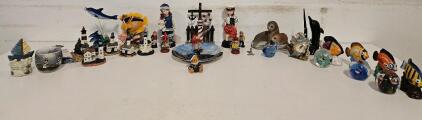 Nautical-themed Lot including: Ship Ornaments, Fish Spheres, Fish Figures, Dolphin Figures, Pen Holder, and Picture Frame, Seal Ceramic, Metal Seal, Mini Lighthouse collection, Sailor Collection.