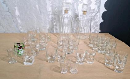 (2) Glass Decanters, (20) Assorted Shot Glasses & (11) Drinking Glasses