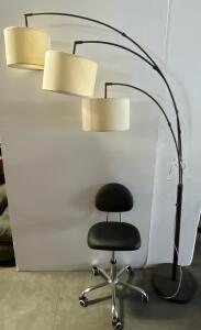 working Three-Arm Arc Floor Lamp with Adjustable Black Metal Arms and Off-White Fabric Shades, Black Swivel Rolling Office Chair with Backrest, 5 Casters, Adjustable Height, Chrome Base