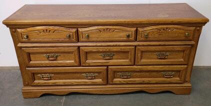 traditional 8-drawer oak dresser features brass-tone metal pulls with ornate designs, carved details on the upper drawers, and a scalloped base