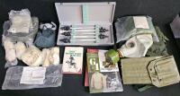(#3) Mixed Military Collectible Lot: Eight Military Thermometers in Matching Cases, Woodland Camo Poncho Cover, Bivy Covers, Gas Mask and Chemical Gloves, GI Collectors Guide Vol 1 & 2, and More!