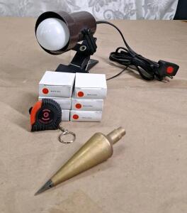 (1) Vintage 6" Brass Plumb Bob, (6) 6-1/2 Foot Keychain Tape Measures & (1) Clip On Work Lamp