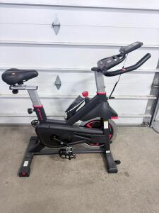 FLEXICHI Indoor Spin Bike with Adjustable Seat and Handlebars, LCD Display, and Transport Wheels