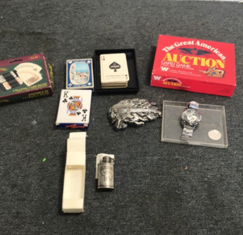 (4) Decks Of Poker Cards (1) Guitar Belt Buckle (1) Music Note Watch (1) Camel Brand Lighter (1) The great American Auction Card Game