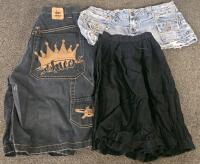 (XA) Mixed Clothing Lot: Paper Shredder w/ Forward and Reverse Modes (Functional), Large Green and Orange Quilt, JNCO Shorts, Jean Shorts, Various Brands of Jeans, Various Dallas Cowboys Shirt and Vest, Other Clothing in Various Sizes, Moccasins, Two Bags - 4