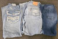 (XA) Mixed Clothing Lot: Paper Shredder w/ Forward and Reverse Modes (Functional), Large Green and Orange Quilt, JNCO Shorts, Jean Shorts, Various Brands of Jeans, Various Dallas Cowboys Shirt and Vest, Other Clothing in Various Sizes, Moccasins, Two Bags - 5